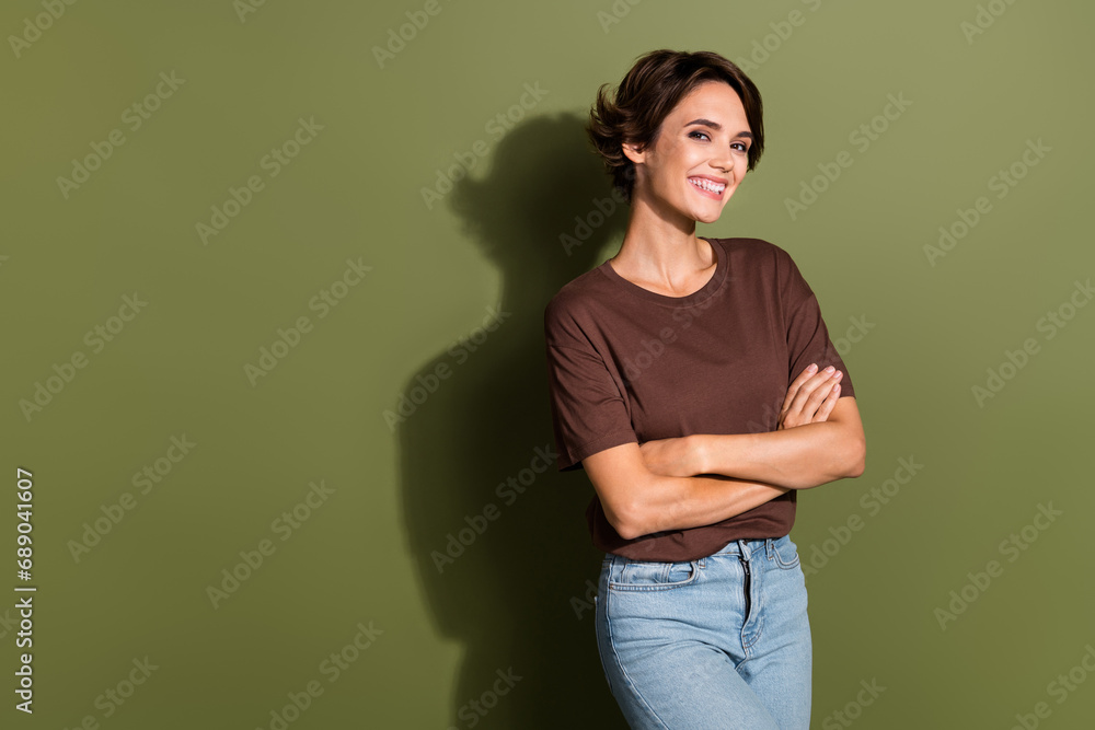 Photo of cheerful woman with bob hair dressed brown t-shirt arms crossed stand near promo empty space isolated on khaki color background Photo of cheerful woman with bob hair dressed brown t-shirt arms crossed stand near promo empty space isolated on khaki color background
