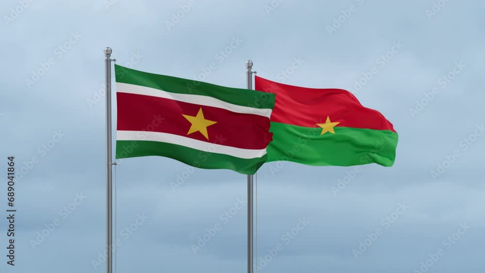 Burkina Faso flag and Suriname flag waving together on cloudy sky, endless seamless loop, two country relations concept Burkina Faso flag and Suriname flag waving together on cloudy sky, endless seamless loop, two country relations concept