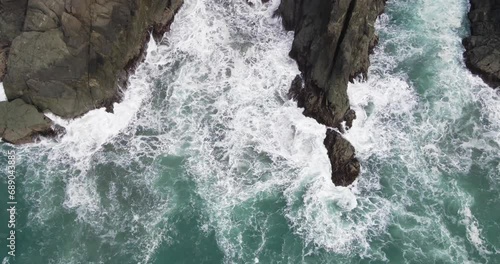 4k drone birds eye view above waves crashing on rocks cliffs brookings oregon coast photo