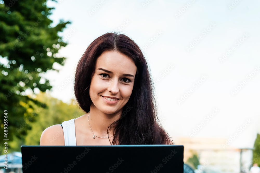 Happy smiling businesswoman brunette working on a laptop in a street cafe.Start-up concept.Closeup. Happy smiling businesswoman brunette working on a laptop in a street cafe.Start-up concept.Closeup.