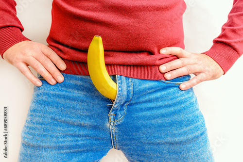 A Man and banana on the white background,close-up.Potency concept, impotence, male strength, pills to improve potency.