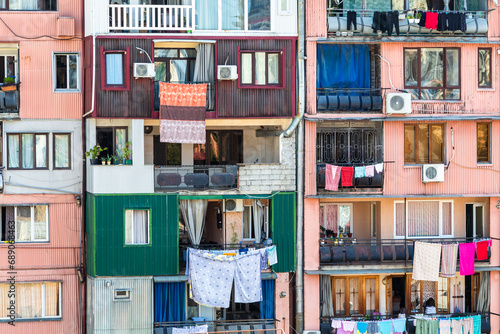 travel to Georgia - facade of multi-storey house in residential district in Batumi city with laundry drying on balcony on sunny morning