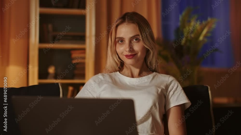A blonde girl blogger spends evening leisure and relaxes, using a laptop to corresponds with friends and subscribers. A smiling young businesswoman controls the operation of her online store remotely A blonde girl blogger spends evening leisure and relaxes, using a laptop to corresponds with friends and subscribers. A smiling young businesswoman controls the operation of her online store remotely