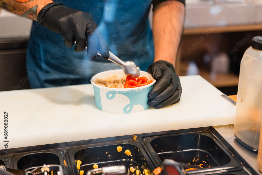 Unrecognizable man chef preparing healthy and delicious poke dish in kitchen Unrecognizable man chef preparing healthy and delicious poke dish in kitchen