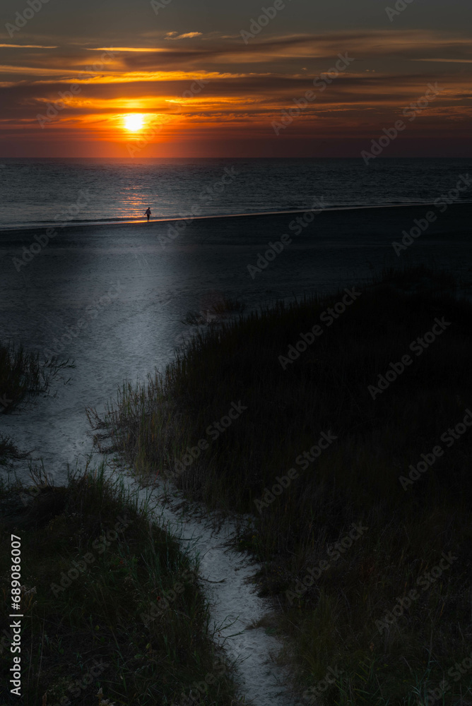 Topsail Island, North Carolina sunrise.  Sunrise over the Atlantic Ocean with a single person silhouetted.