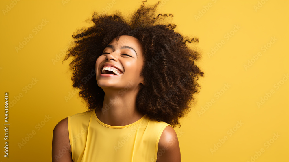 Smiling black woman afro, with dark, curly hair wearing a sleeveless yellow top, against a solid yellow background Smiling black woman afro, with dark, curly hair wearing a sleeveless yellow top, against a solid yellow background