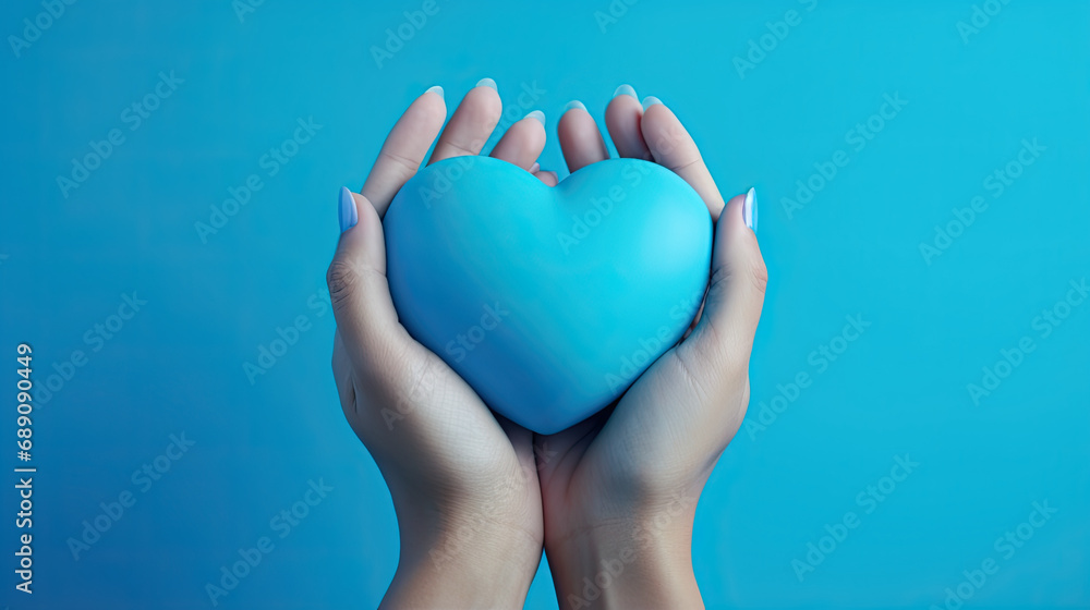 female hand holding blue heart on blue background