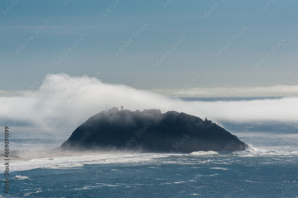 A layer of fog is rolling out over Point Sur, California.
