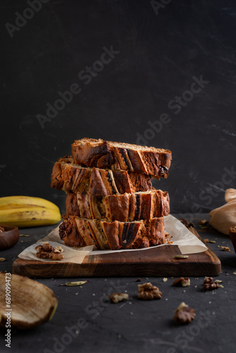 Banana bread on a dark background. Homemade cakes with banana and nuts.