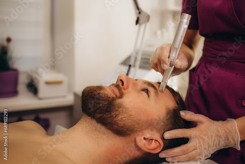Male cosmetology. Dermastamp fractional mesotherapy treatment for man in cosmetology clinic.