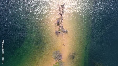 Aerial top-view drone shot capturing the shoreline of a serene lake as the drone glides forward into the expansive blue of the water in Whiskeytown Reservoir, California. photo