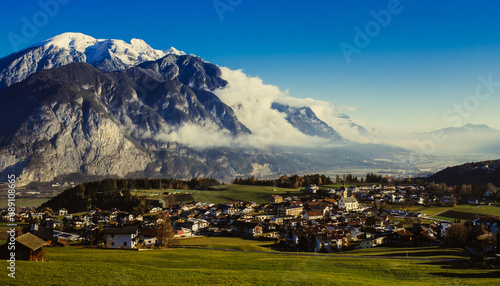 Mountain landscape with a village in foreground and clouds during daylight