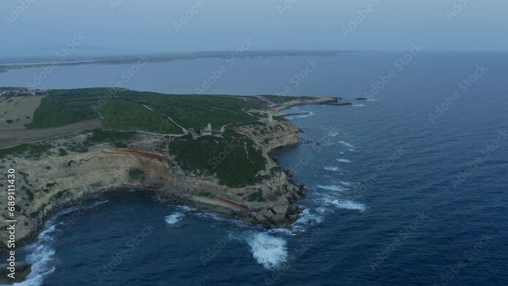 Aerial drone view of Capo Mannu cape lighthouse at sunset in Sardinia, Italy Aerial drone view of Capo Mannu cape lighthouse at sunset in Sardinia, Italy