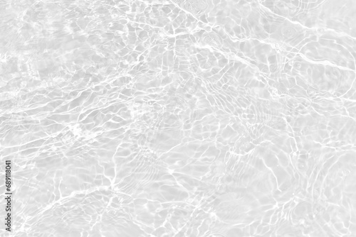 White water with ripples on the surface. Defocus blurred transparent white colored clear calm water surface texture with splashes and bubbles. Water waves with shining pattern texture background.