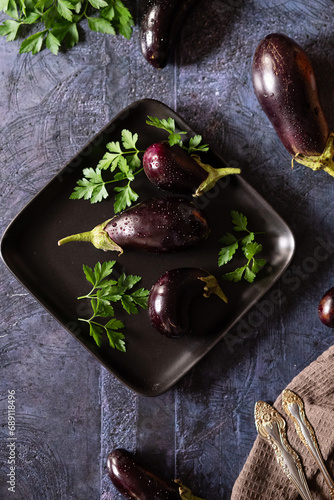 Raw fresh striped eggplants, dark background, rustic style, selective focus, low key