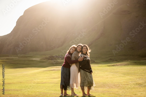 A group of girls tourists in colorful national Icelandic sweaters at sunset 
