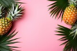 Pineapples and tropical palm leaves on punchy pastel pink background. Summer concept. Creative flat lay with copy space. Top view