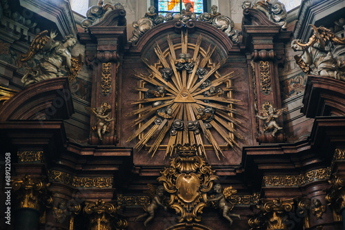 A golden flaming, radiant delta with the all-seeing eye of the Christian God or the great architect of the Masons, surrounded by seraphim. Relief and sculptures. Jesuit Church in Lviv, Ukraine.
