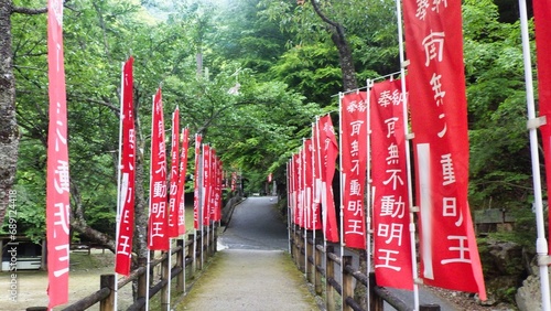 山間部の田舎のお寺の不動明王と赤い参道幟旗