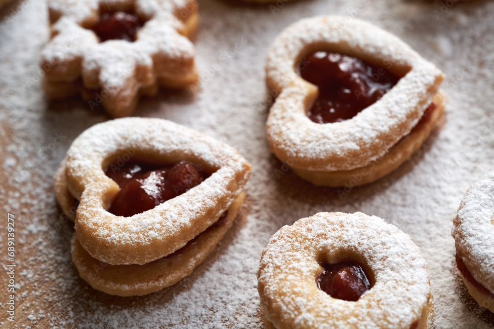 Heart shaped Linzer Christmas cookies filled with strawberry marmalade, dusted with sugar