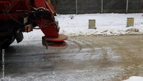 Ice service for cleaning streets in winter. The machine sprinkles the roads with salt and chemicals against traffic accidents.  photo