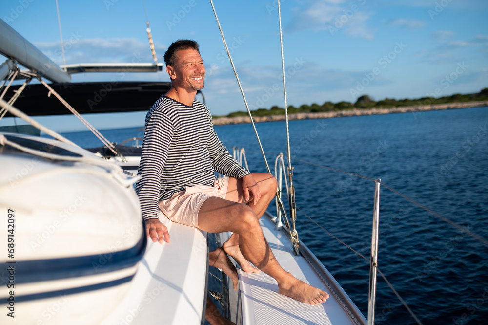 Man on a yacht smiling and feeling peaceful Man on a yacht smiling and feeling peaceful