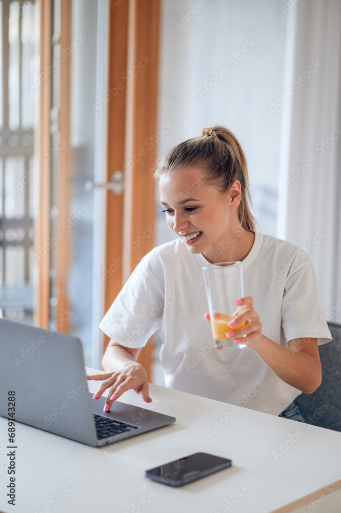 Young girl working from home and having some juice Young girl working from home and having some juice
