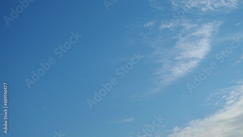 Beautiful blue sky with light clouds background. Natural autumn sky. Delicate hue paints the atmosphere with sense of tranquility. Sunny day travel. Weather forecasting. Real time. Slow motion