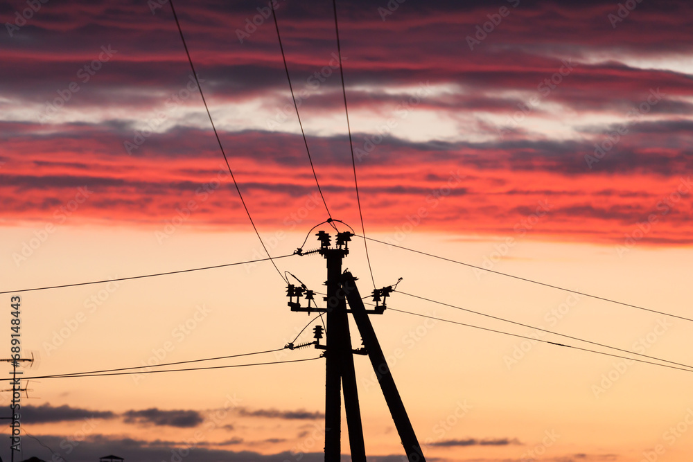Electric line against colorful sky at sunset Electric line against colorful sky at sunset