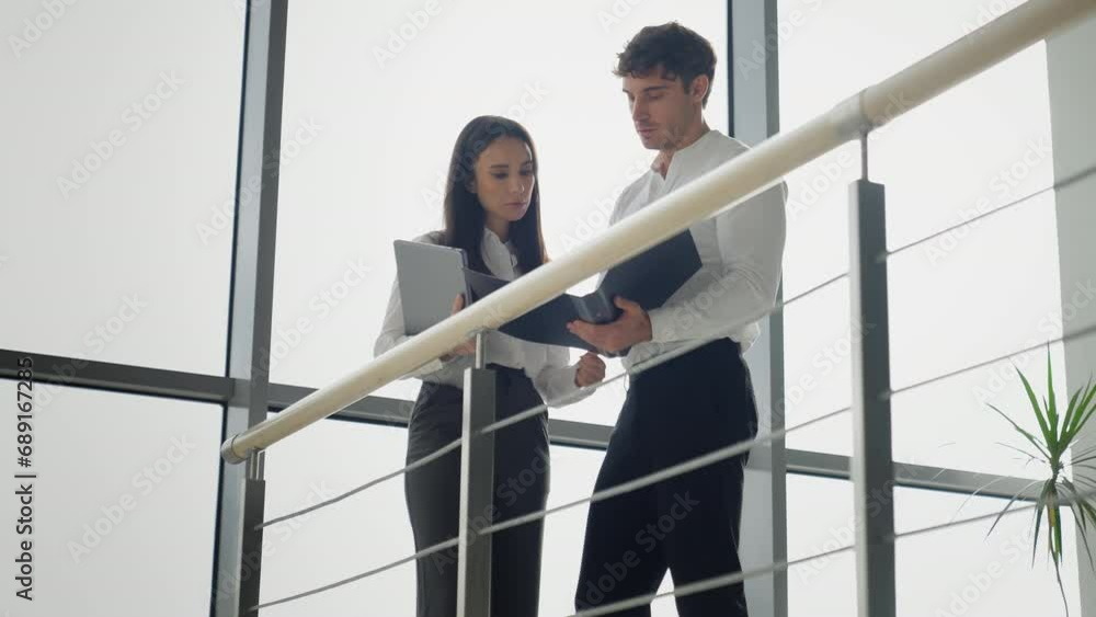 Caucasian businesswoman and businessman discuss documents in company hall business people male and female woman and man coworkers partners colleagues manager discussing data from papers office lobby Caucasian businesswoman and businessman discuss documents in company hall business people male and female woman and man coworkers partners colleagues manager discussing data from papers office lobby