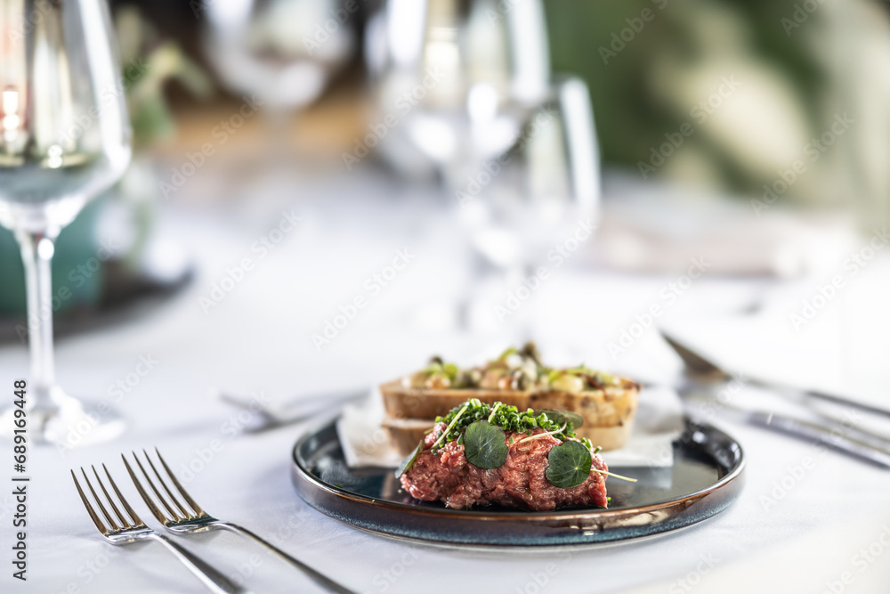 Steak Tartare with bread toasts served on a restaurant table Steak Tartare with bread toasts served on a restaurant table