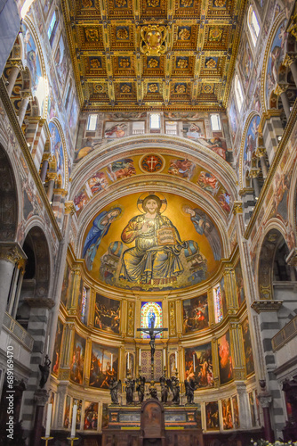 Pisa, Italy - November 24, 2023: View of the apse with Mosaic of Christ Pantocrator with gilded coffered ceiling above inside the Primatial Cathedral of Santa Maria Assunta photo