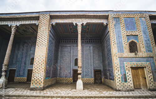 Facades of buildings covered with ceramic mosaic tiles, with wooden columns in the historical city of Khiva in Khorezm photo