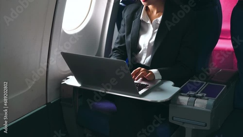 Successful Asian business woman, Business woman working in airplane cabin during flight on laptop computer