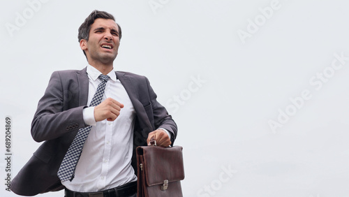 Studio shot of a mature businessman running with a briefcase iso photo