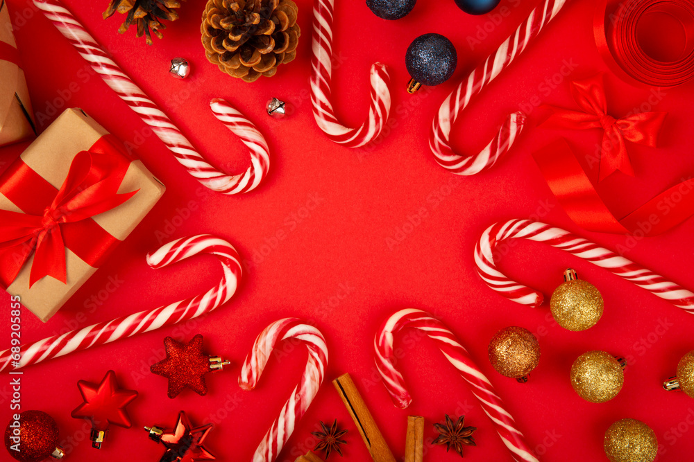 Christmas candy canes on a red background. Holiday greeting card. Concept for Christmas and New Year holidays. Winter. Flatlay, top view, copy space.