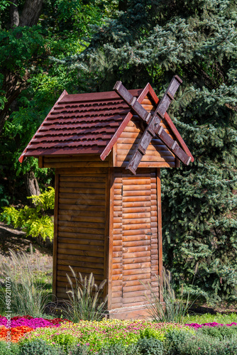 Fototapeta Naklejka Na Ścianę i Meble -  A small wooden decorative mill to decorate city park in Kyiv, Ukraine, closeup. Ecology and environment concept