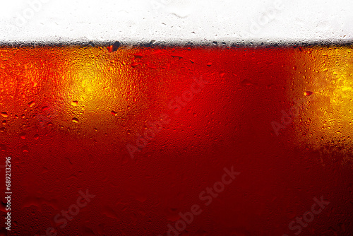 Soft drink glass with ice splash on dark background. Cola glass in celebration party concept.  photo