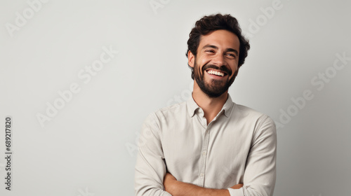Cheerful man wearing a white shirt, smiling against grey background
