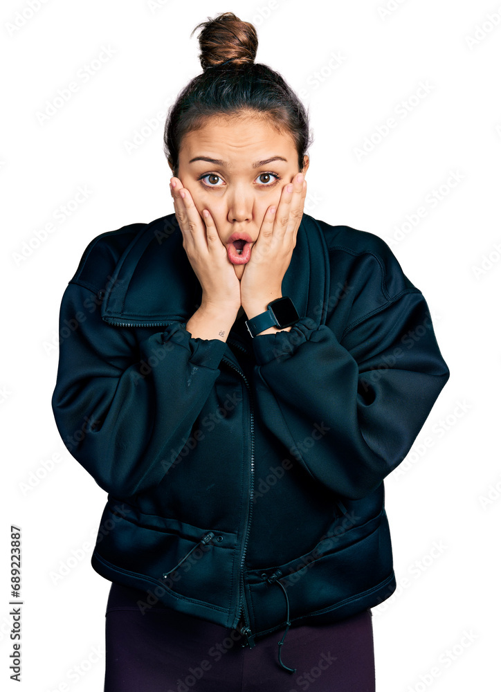 Young hispanic girl wearing sportswear afraid and shocked, surprise and amazed expression with hands on face Young hispanic girl wearing sportswear afraid and shocked, surprise and amazed expression with hands on face