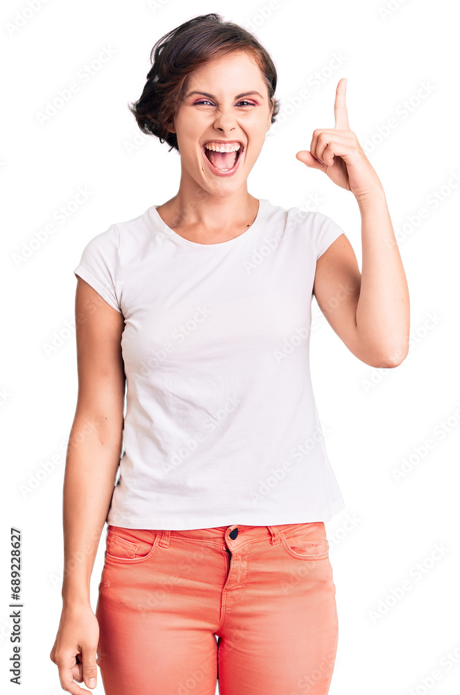 Beautiful young woman with short hair wearing casual clothes pointing finger up with successful idea. exited and happy. number one. Beautiful young woman with short hair wearing casual clothes pointing finger up with successful idea. exited and happy. number one.