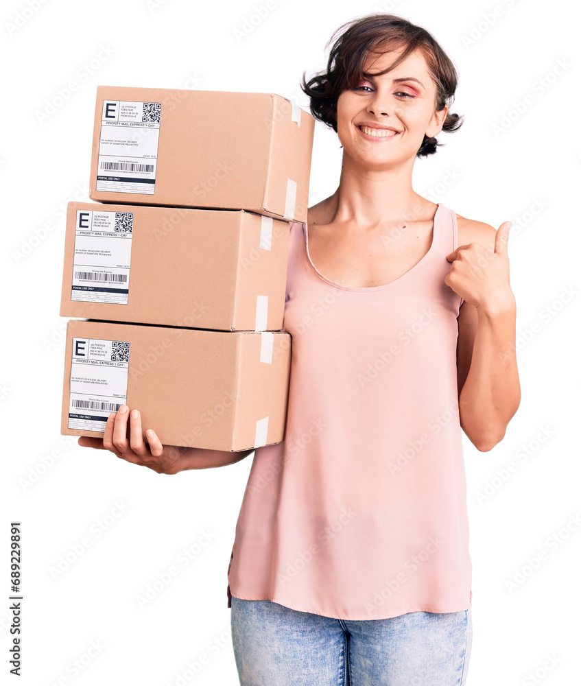 Beautiful young woman with short hair holding delivery packages pointing finger to one self smiling happy and proud Beautiful young woman with short hair holding delivery packages pointing finger to one self smiling happy and proud