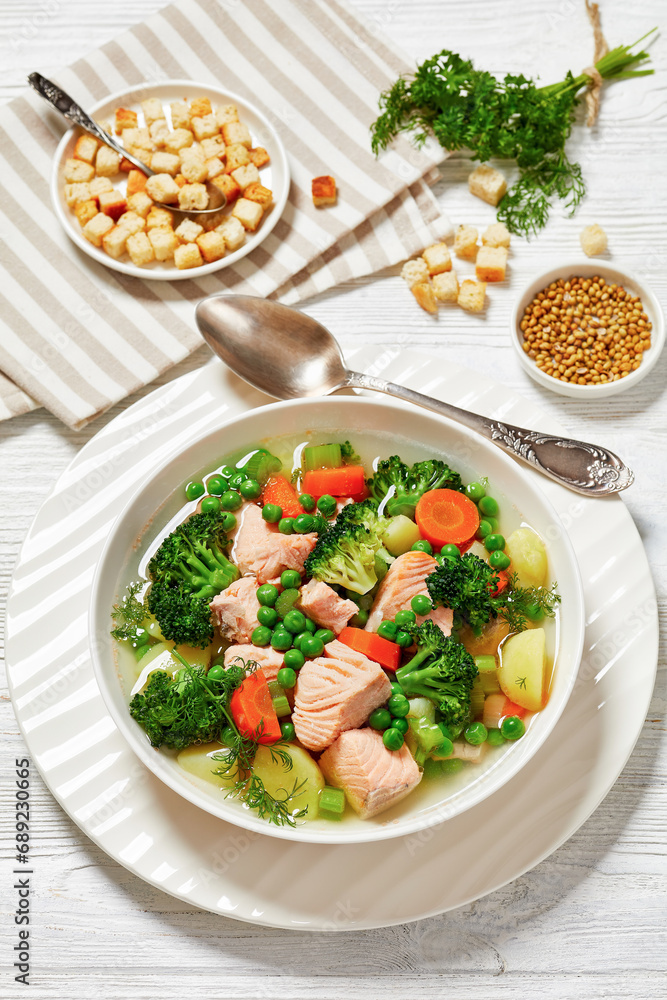 salmon, veggies and green herbs soup in bowl salmon, veggies and green herbs soup in bowl