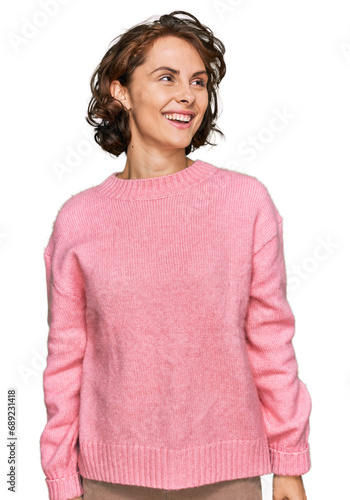 Young hispanic woman wearing casual clothes looking away to side with smile on face, natural expression. laughing confident.