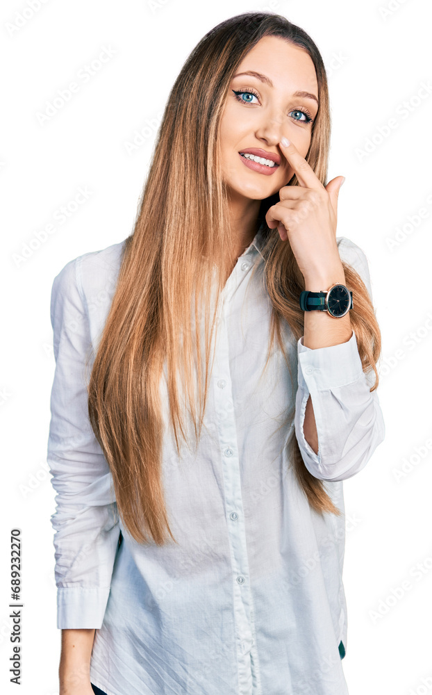Beautiful caucasian woman wearing casual white shirt pointing with hand finger to face and nose, smiling cheerful. beauty concept Beautiful caucasian woman wearing casual white shirt pointing with hand finger to face and nose, smiling cheerful. beauty concept
