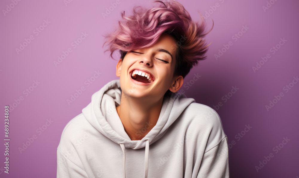 Radiant Young Person with Short Hair Laughing Joyfully in a Casual Hoodie Against a Soft Purple Background, Exuding Happiness and Youthful Energy