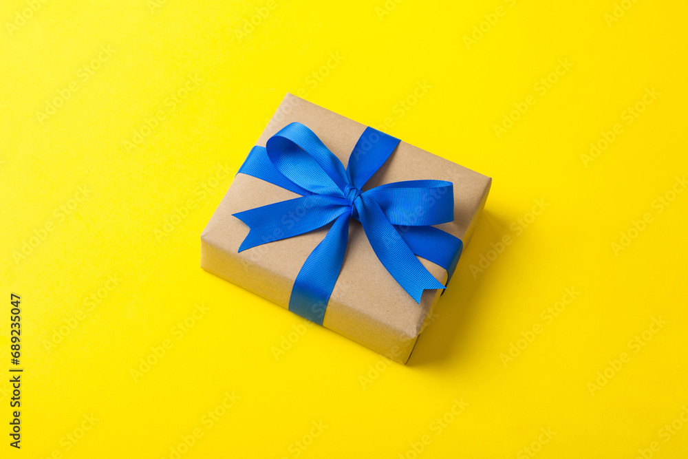 Wrapped christmas or other holiday handmade present in craft paper with colored ribbon. Present box, decoration of gift on table, top view with copy space Wrapped christmas or other holiday handmade present in craft paper with colored ribbon. Present box, decoration of gift on table, top view with copy space