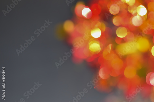 Red lights - stars hanging on fir branches with sparkling lights and bokeh in abstract background.