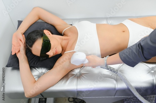 Young woman making body hair removal laser depilation in beauty center