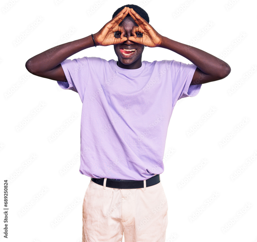 Fototapeta premium Young african american man wearing casual clothes doing ok gesture like binoculars sticking tongue out, eyes looking through fingers. crazy expression.